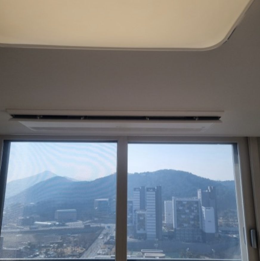 거실 창가와 외부 배관이 보이는 최종 마감