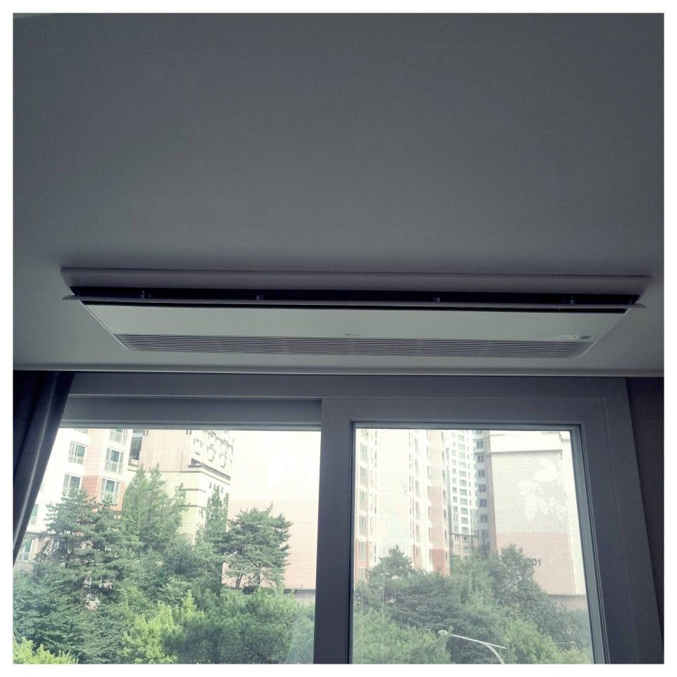 거실 천장에 매립된 실내기와 창가 풍경