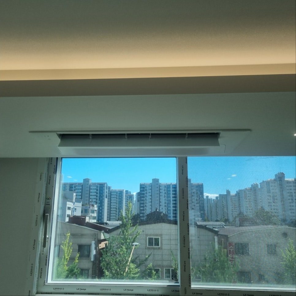 거실 창가와 어우러진 시스템 에어컨 전경