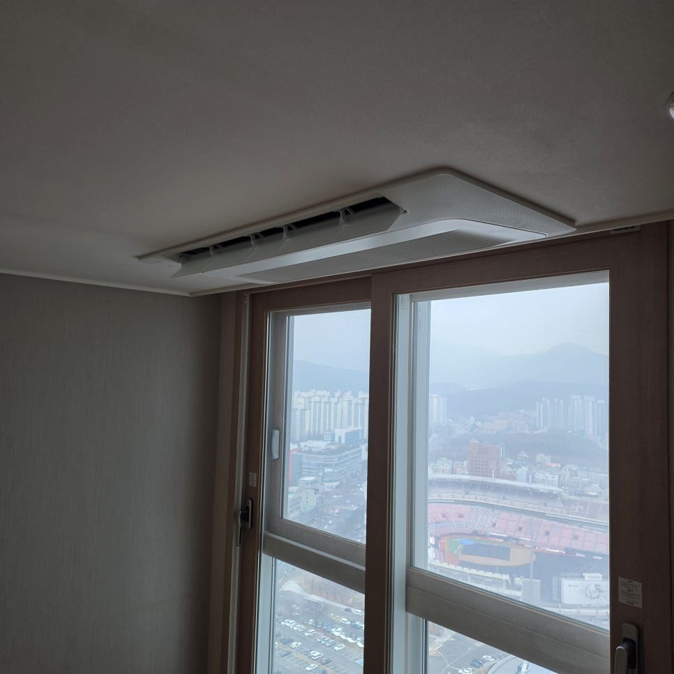 도시 풍경이 보이는 거실과 매립된 시스템에어컨