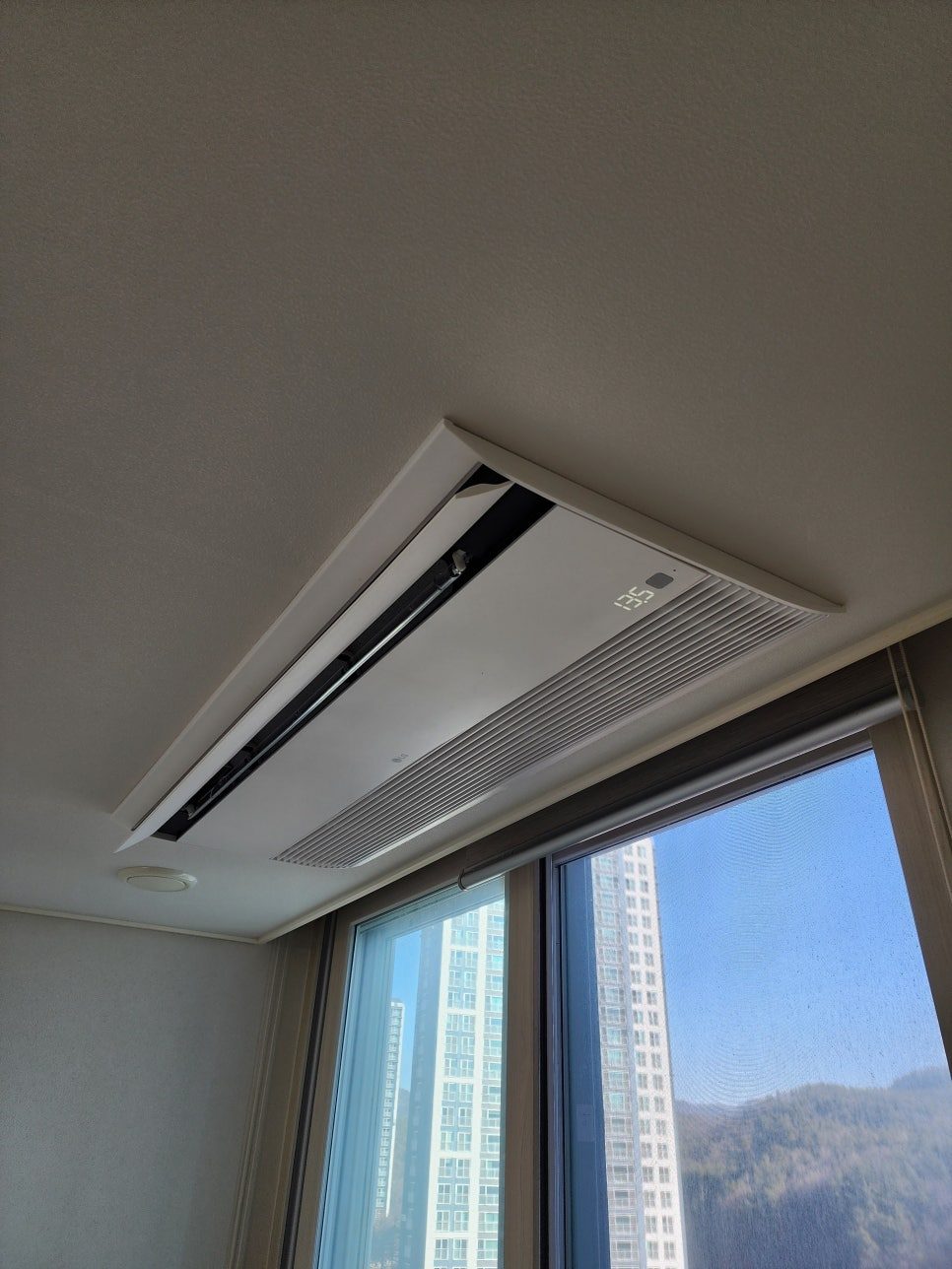 창가 풍경이 돋보이는 거실 공간의 실내기